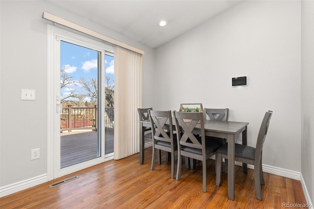 dining room featuring visible vents, wood finished floors, recessed lighting, baseboards, and vaulted ceiling