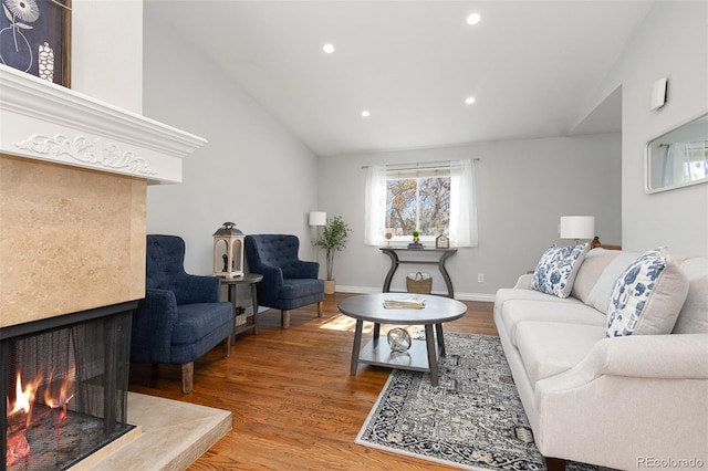 living room featuring baseboards, a multi sided fireplace, recessed lighting, wood finished floors, and high vaulted ceiling