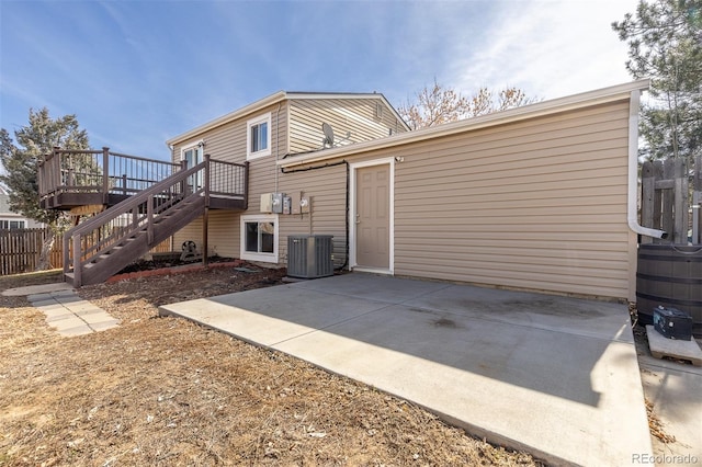 back of property with fence, a wooden deck, central AC unit, stairs, and a patio area