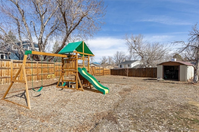 view of playground featuring a storage shed, a fenced backyard, and an outdoor structure