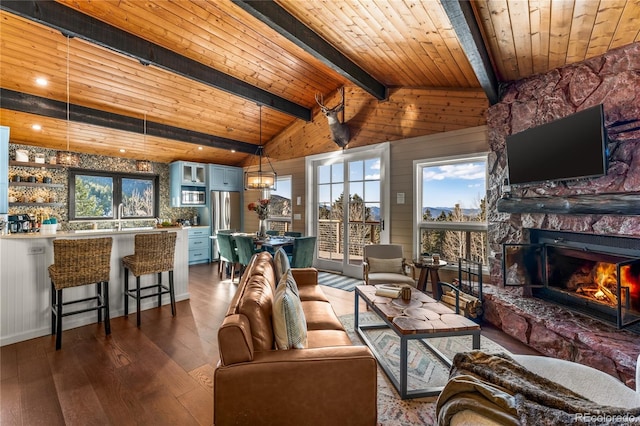 living area featuring dark wood finished floors, a fireplace, wooden ceiling, and wood walls