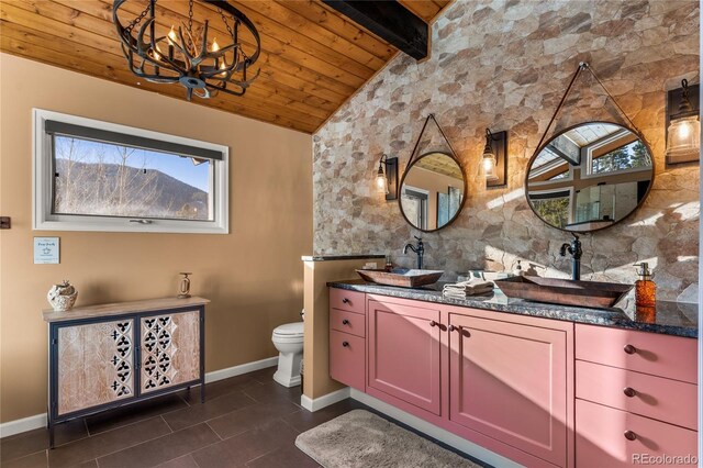 bathroom featuring baseboards, wooden ceiling, a chandelier, toilet, and double vanity