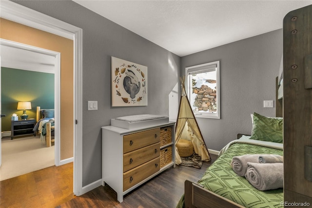 bedroom with dark wood-type flooring and baseboards