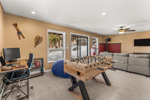recreation room featuring carpet floors, a wood stove, a ceiling fan, an office area, and recessed lighting