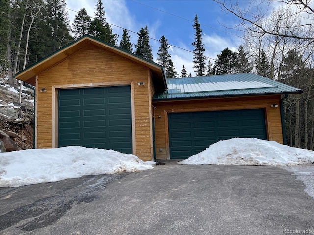 32094 Christopher Ln, Conifer, CO 80433 - snow covered garage featuring asphalt driveway