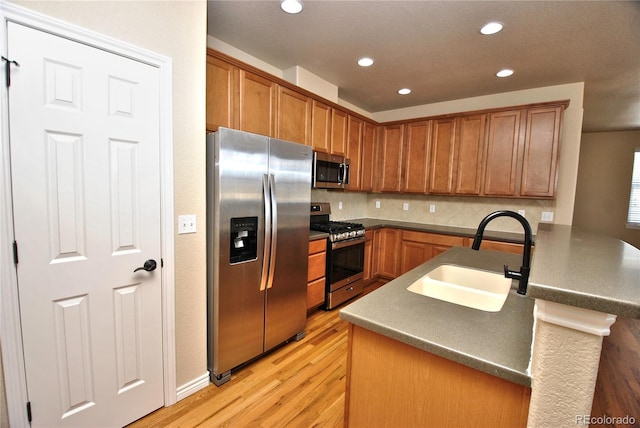 10835 Tincup Creek Pt, Colorado Springs, CO 80908 - kitchen featuring stainless steel appliances, a sink, brown cabinetry, recessed lighting, and light wood finished floors