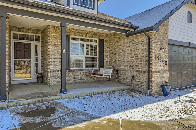 doorway to property featuring covered porch and brick siding