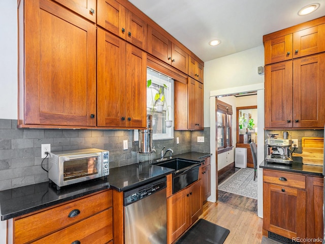 kitchen with light wood-type flooring, dishwasher, backsplash, and sink