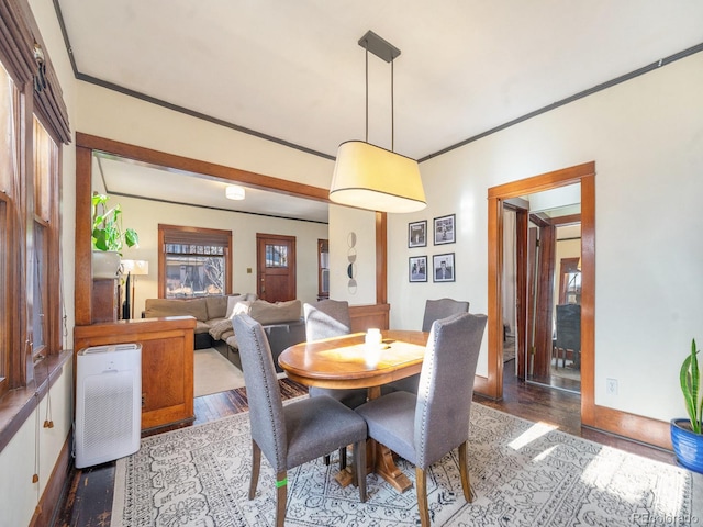 dining area featuring light wood-type flooring and crown molding