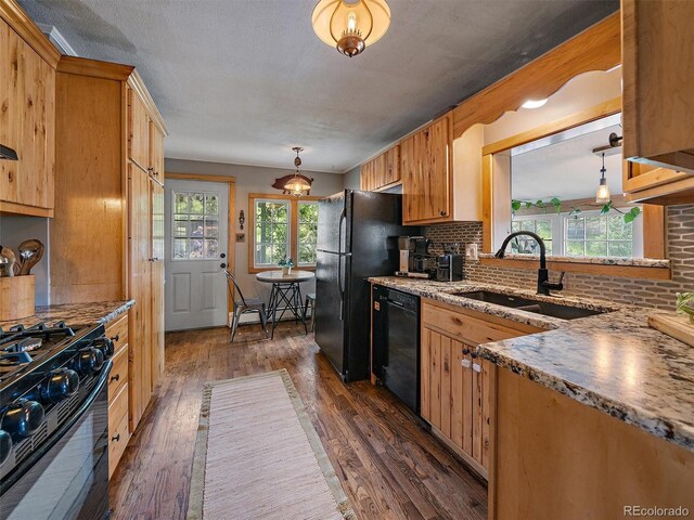 27385 Spruce Ln, Evergreen, CO 80439 - kitchen with black appliances, dark wood-style flooring, decorative backsplash, decorative light fixtures, and light stone counters