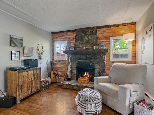 27385 Spruce Ln, Evergreen, CO 80439 - living area featuring wood finished floors, a stone fireplace, and baseboard heating