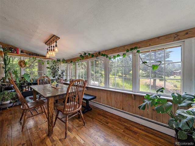 27385 Spruce Ln, Evergreen, CO 80439 - sunroom / solarium featuring a baseboard radiator, a textured ceiling, wood finished floors, plenty of natural light, and vaulted ceiling