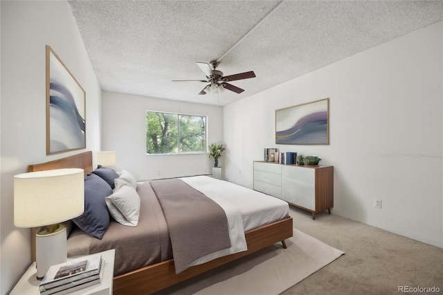 bedroom featuring ceiling fan, carpet floors, and a textured ceiling