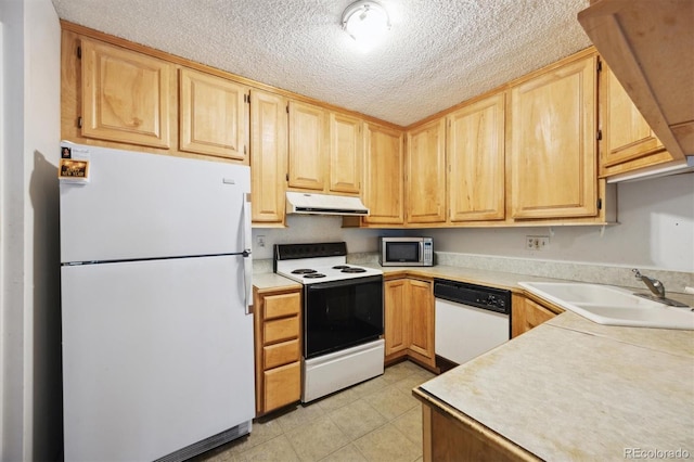 kitchen with light brown cabinets, light tile patterned flooring, sink, white appliances, and a textured ceiling