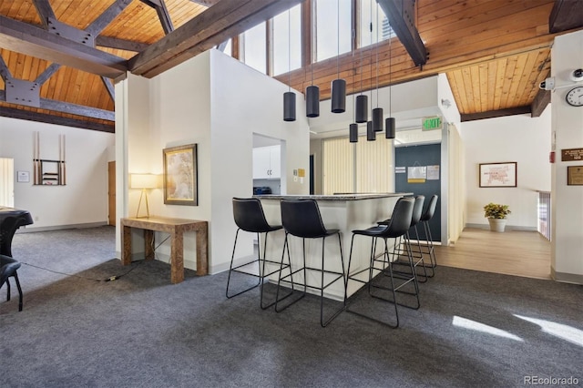 kitchen featuring wood ceiling, a towering ceiling, and beam ceiling