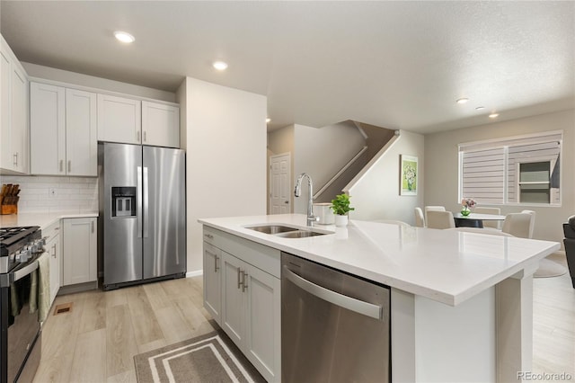 6150 Sugarloaf St, Brighton, CO 80601 - kitchen with appliances with stainless steel finishes, light wood-type flooring, light countertops, decorative backsplash, and recessed lighting