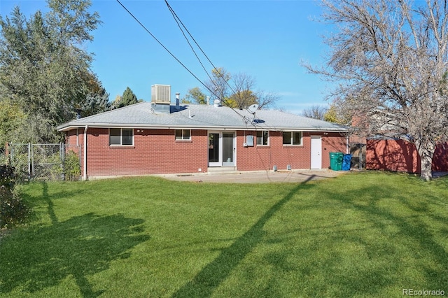 rear view of property with a lawn and a patio