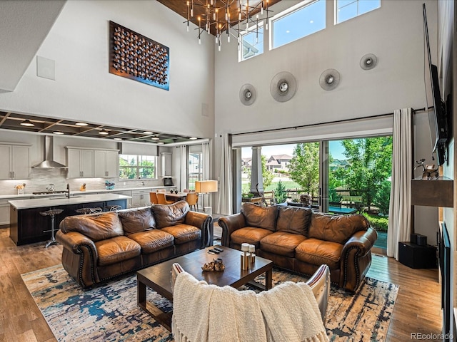 1291 Fountain Ln, Erie, CO 80516 - living area with a high ceiling, light wood-type flooring, a chandelier, and healthy amount of natural light