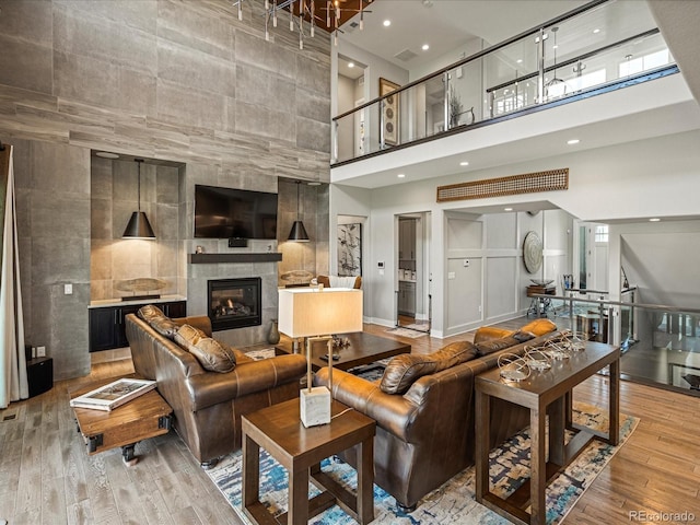 1291 Fountain Ln, Erie, CO 80516 - living room with a towering ceiling, a tile fireplace, wood finished floors, and recessed lighting