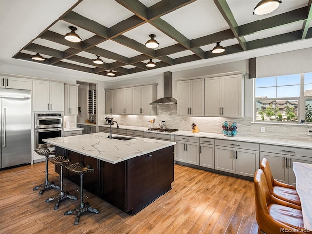 1291 Fountain Ln, Erie, CO 80516 - kitchen featuring appliances with stainless steel finishes, wall chimney range hood, coffered ceiling, a kitchen breakfast bar, and decorative backsplash