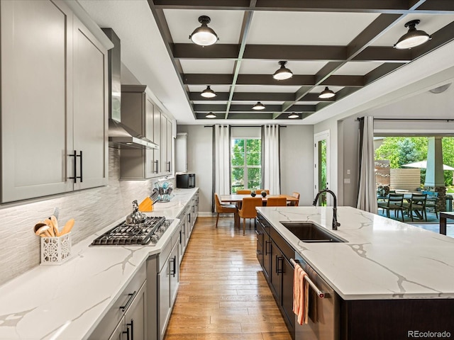 1291 Fountain Ln, Erie, CO 80516 - kitchen featuring appliances with stainless steel finishes, wall chimney exhaust hood, coffered ceiling, tasteful backsplash, and light wood finished floors