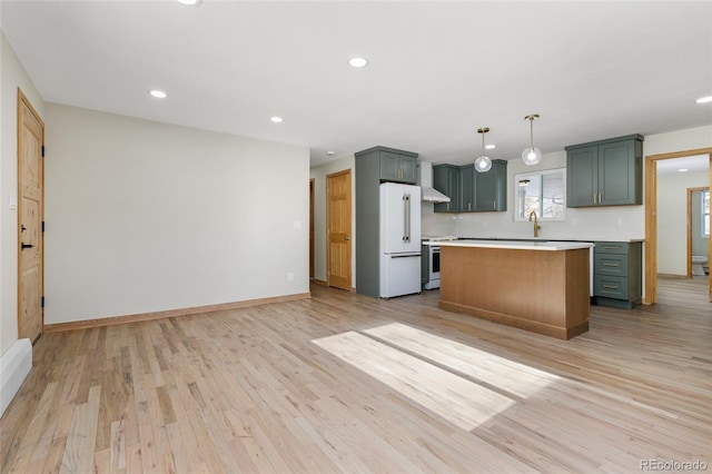 kitchen with hanging light fixtures, a kitchen island, light wood-type flooring, and white appliances