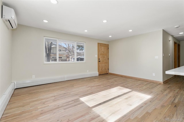 unfurnished living room with a baseboard heating unit, light hardwood / wood-style floors, and an AC wall unit