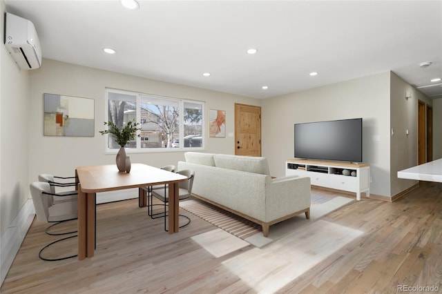 living room with a wall unit AC and light hardwood / wood-style flooring