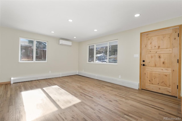 empty room featuring light hardwood / wood-style floors and a wall mounted AC