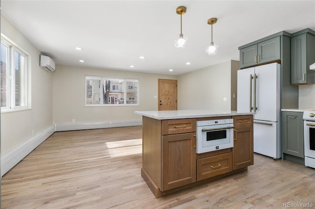 kitchen with a kitchen island, a wall mounted AC, hanging light fixtures, light hardwood / wood-style floors, and white appliances