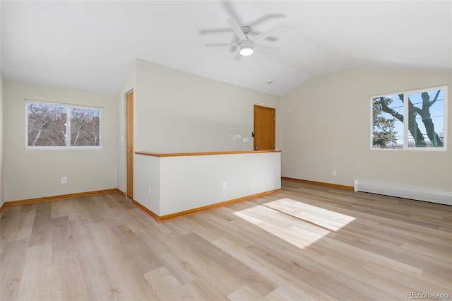 unfurnished room featuring ceiling fan, vaulted ceiling, light hardwood / wood-style floors, and a baseboard radiator