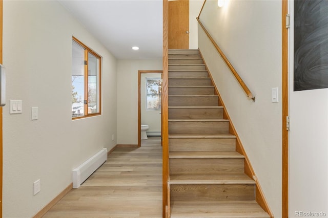 stairs with wood finished floors, baseboards, a baseboard radiator, recessed lighting, and baseboard heating