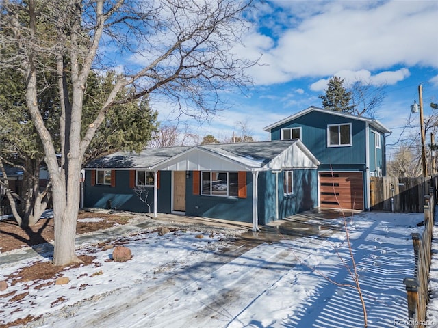 view of front of home featuring covered porch, an attached garage, and fence