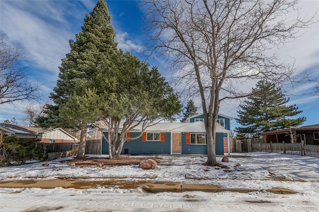 view of front facade featuring driveway and fence