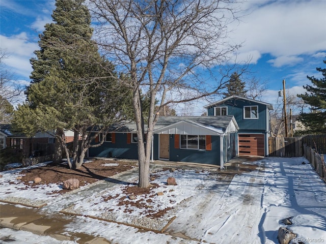 view of front of home featuring driveway, an attached garage, and fence