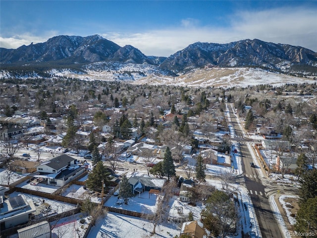 snowy aerial view with a mountain view and a residential view