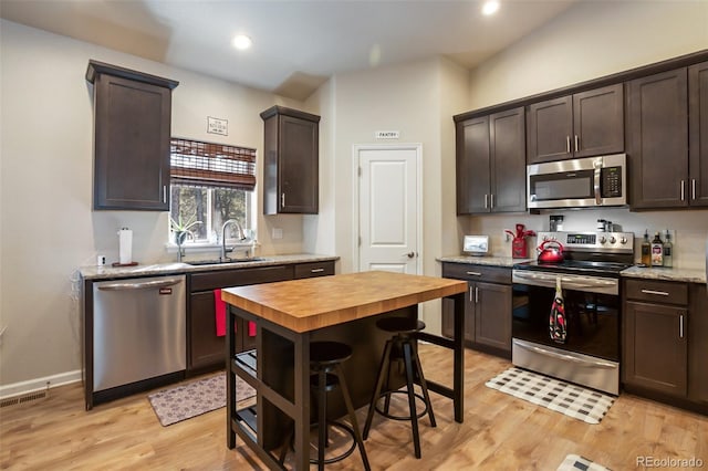 kitchen featuring light hardwood / wood-style flooring, sink, dark brown cabinets, and stainless steel appliances