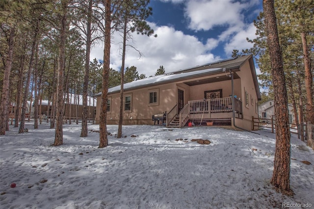 view of snow covered back of property