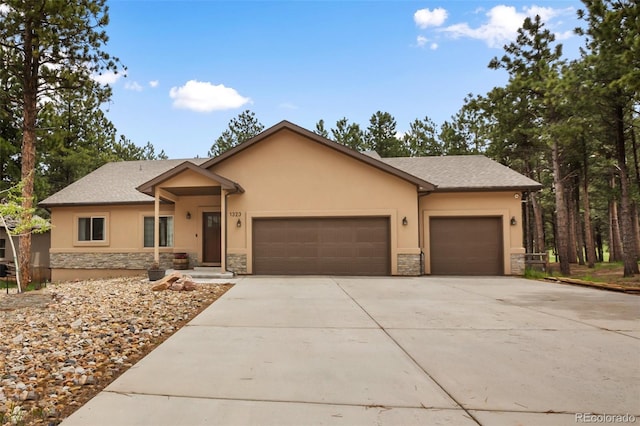 1323 Firestone Dr, Woodland Park, CO 80863 - view of front of house featuring stone siding, stucco siding, an attached garage, and concrete driveway