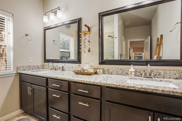 1323 Firestone Dr, Woodland Park, CO 80863 - bathroom featuring double vanity, plenty of natural light, a tile shower, and baseboards