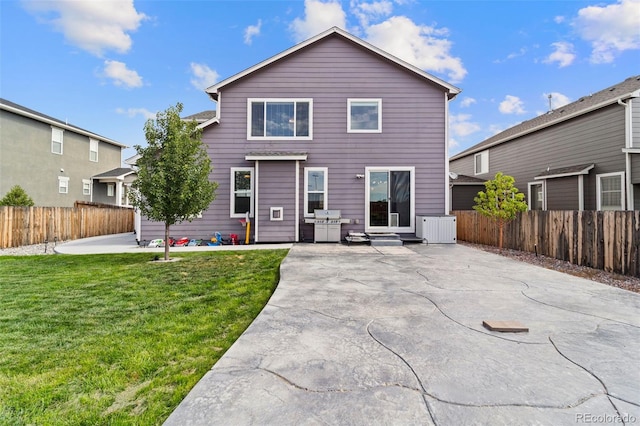 rear view of property featuring a patio, a lawn, fence, and central AC