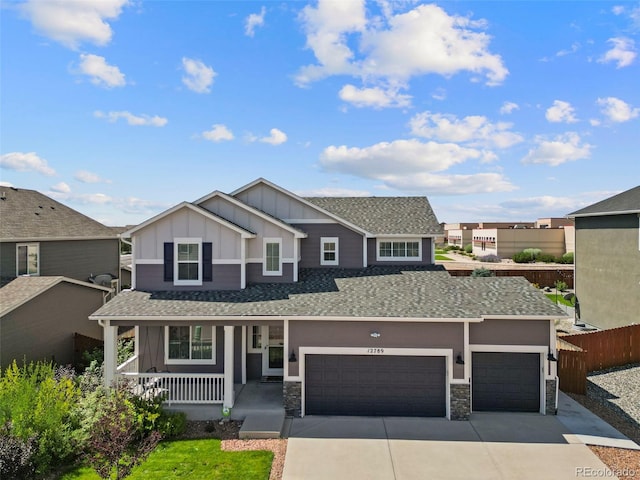 view of front of property featuring an attached garage, fence, board and batten siding, covered porch, and driveway