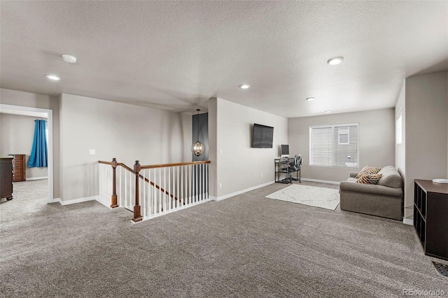 carpeted living area with a textured ceiling, baseboards, and recessed lighting