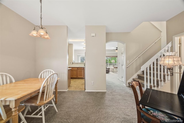 228 Quari St, Aurora, CO 80011 - dining space featuring stairway, carpet flooring, arched walkways, and a ceiling fan