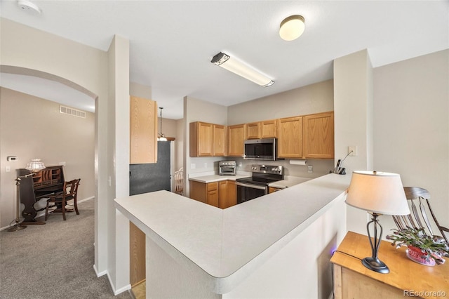 228 Quari St, Aurora, CO 80011 - kitchen with stainless steel appliances, light countertops, carpet floors, a peninsula, and arched walkways