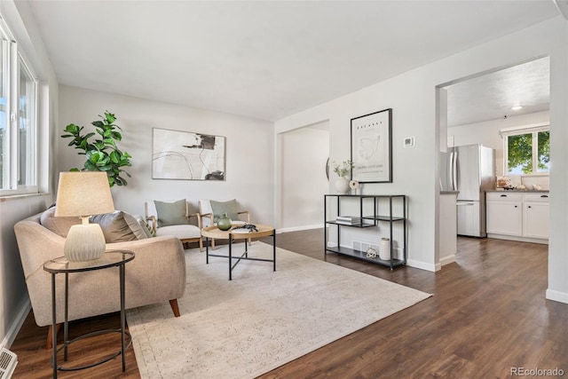 7565 Newland St, Arvada, CO 80003 - living room featuring dark wood-type flooring and baseboards