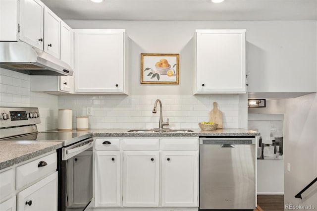 7565 Newland St, Arvada, CO 80003 - kitchen with stainless steel appliances, under cabinet range hood, white cabinets, and tasteful backsplash