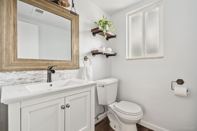 7565 Newland St, Arvada, CO 80003 - half bath with backsplash, wood finished floors, and vanity