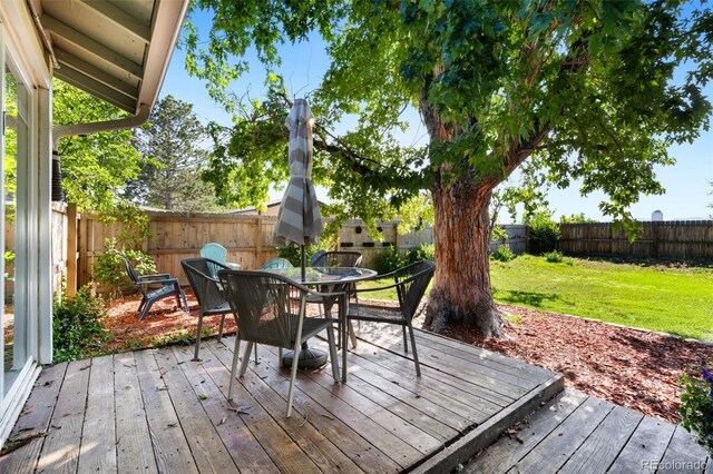 7565 Newland St, Arvada, CO 80003 - wooden deck with a fenced backyard and outdoor dining area