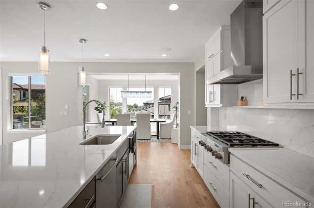 2136 S Juniper St, Lakewood, CO 80228 - kitchen with wall chimney range hood, a sink, appliances with stainless steel finishes, healthy amount of natural light, and recessed lighting